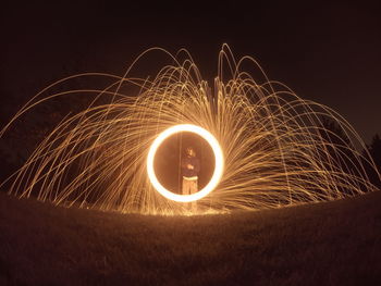 Man spinning wire wool at night