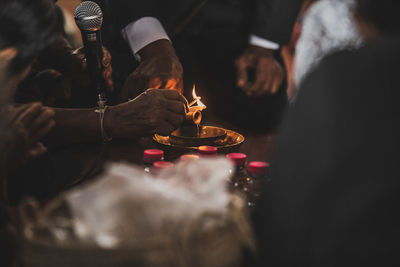 People holding burning candle