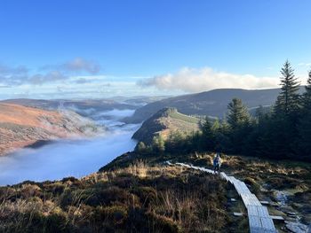 Scenic view of irish mountains against sky wondering woman