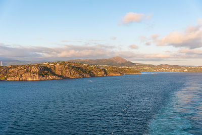 Scenic view of sea and mountains against sky