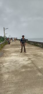 Full length of man standing on road against sky