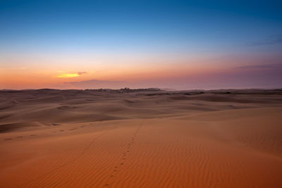 Scenic view of desert against sky during sunset