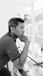 Side view of young man looking away at home