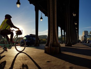 People riding bicycle on bridge in city