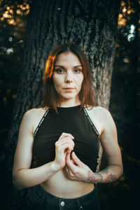 Portrait of young woman standing in forest