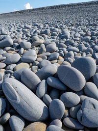 Stones in pebbles at beach against sky