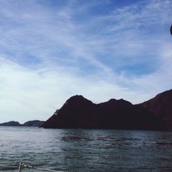 Scenic view of sea and mountains against sky