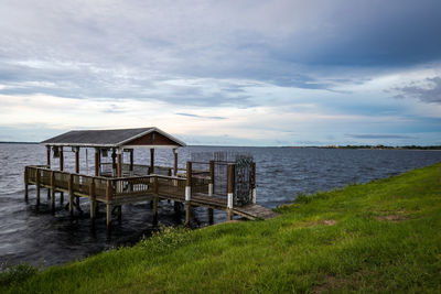 Gazebo over lake against sky