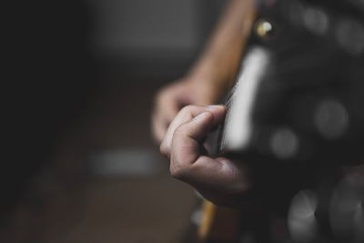 Midsection of man playing guitar