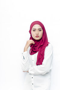 Portrait of a young woman against white background