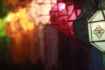 Close-up of illuminated lantern hanging against wall in building