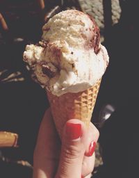 Cropped hand holding ice cream cone