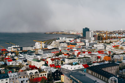 High angle view of townscape by sea against sky