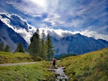 Rear view of person on snowcapped mountains against sky