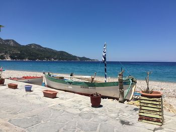 Boats moored on shore against clear sky