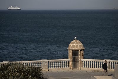 Lighthouse by sea against sky