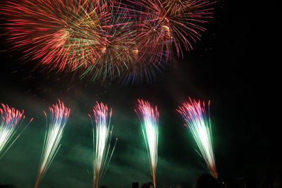 Low angle view of fireworks display at night