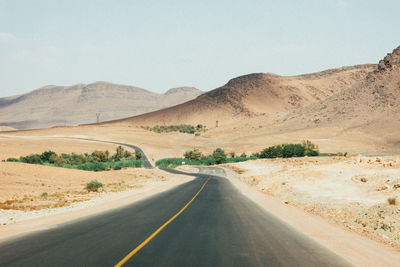 Empty road along countryside landscape