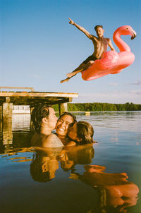 Portrait of young woman with arms raised in lake