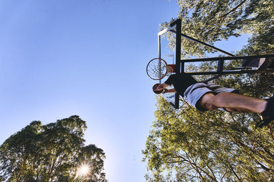 Tilt shot of man playing basketball on court at park