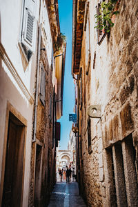 People walking on footpath amidst buildings in city