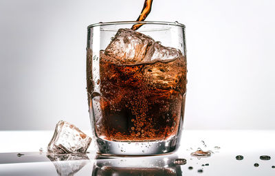 Close-up of drink in glass against white background