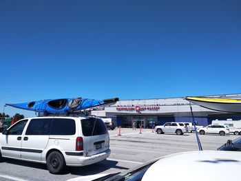 Vehicles on road against clear blue sky