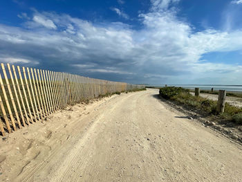 Road leading towards landscape against sky