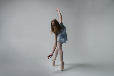 Ballet dancing against gray background