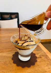 Close-up of hand holding drink on table