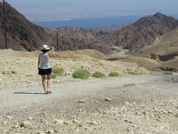 Rear view of woman walking on mountain