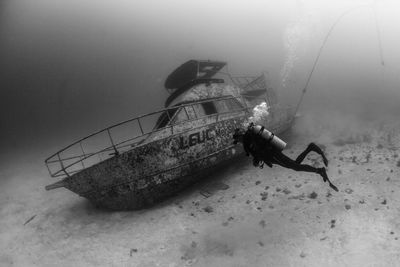 Scuba diver exploring sunken ship underwater