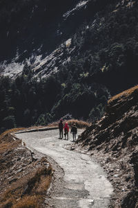 People walking on rocks against mountain