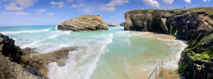 Panoramic view of rocks on beach against sky