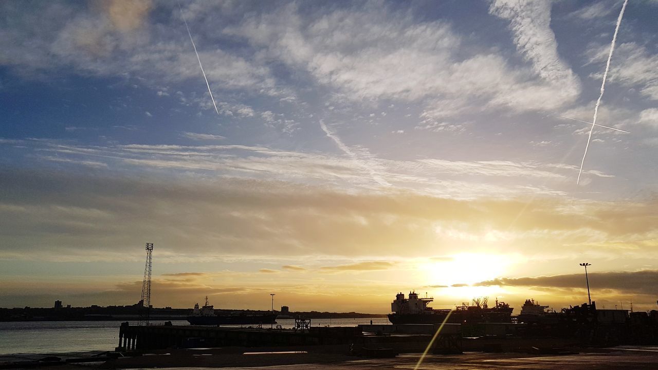 SILHOUETTE CRANES AGAINST SKY AT SUNSET