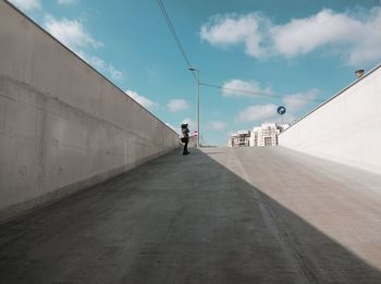 Rear view of people walking on footpath against sky