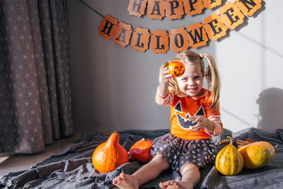 A little girl in a pumpkin costume for halloween, trick or treat. children celebrate halloween