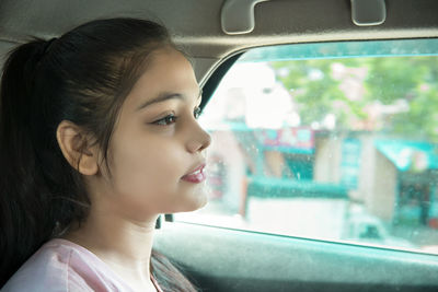 Close-up of young woman looking through window