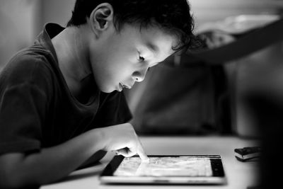 Side view of boy using digital tablet