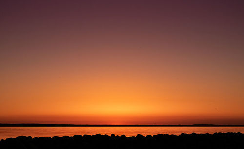 Scenic view of sea against orange sky