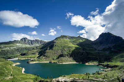 Scenic view of lake by mountains against sky