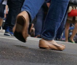 Low section of woman walking on street