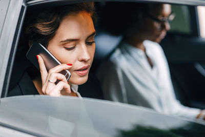 Close-up of woman using mobile phone in car