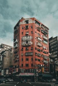 View of buildings in city against cloudy sky