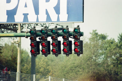 Low angle view of road signal by billboard