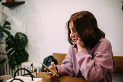 Young attractive woman in a cafe with a smartphone