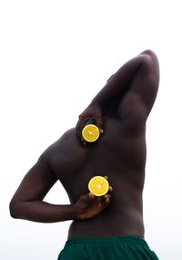 Midsection of woman holding apple against white background