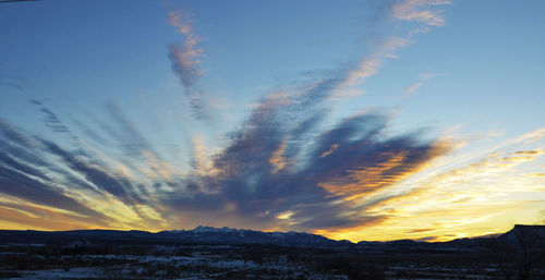 Scenic view of snowcapped mountains against sky during sunset