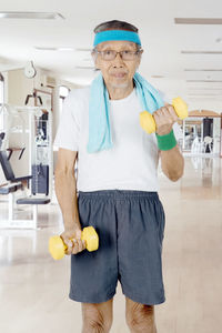 Portrait of senior man exercising in gym