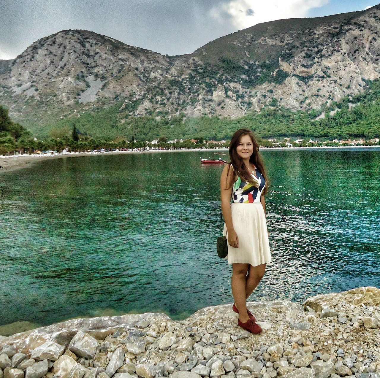 young adult, water, person, lifestyles, casual clothing, looking at camera, portrait, young women, leisure activity, full length, standing, smiling, mountain, front view, lake, happiness, three quarter length, rock - object